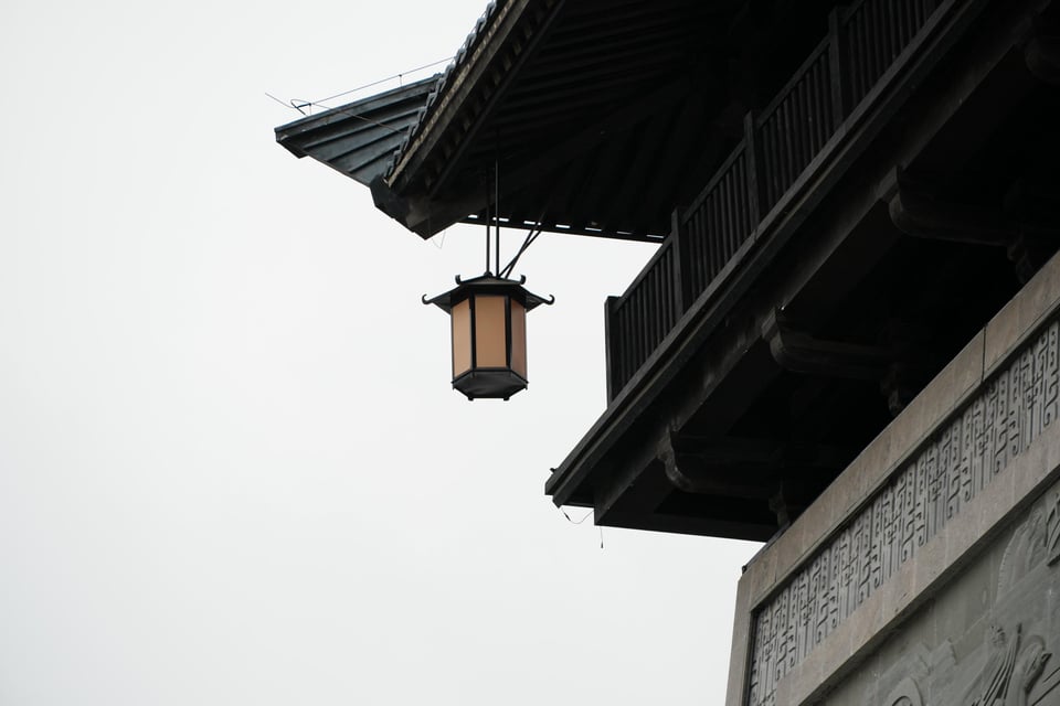 A lantern hanging from the eaves of a gate at Caowei Ancient City.