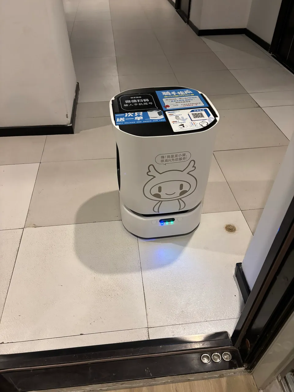 A delivery robot arriving at an apartment doorway.