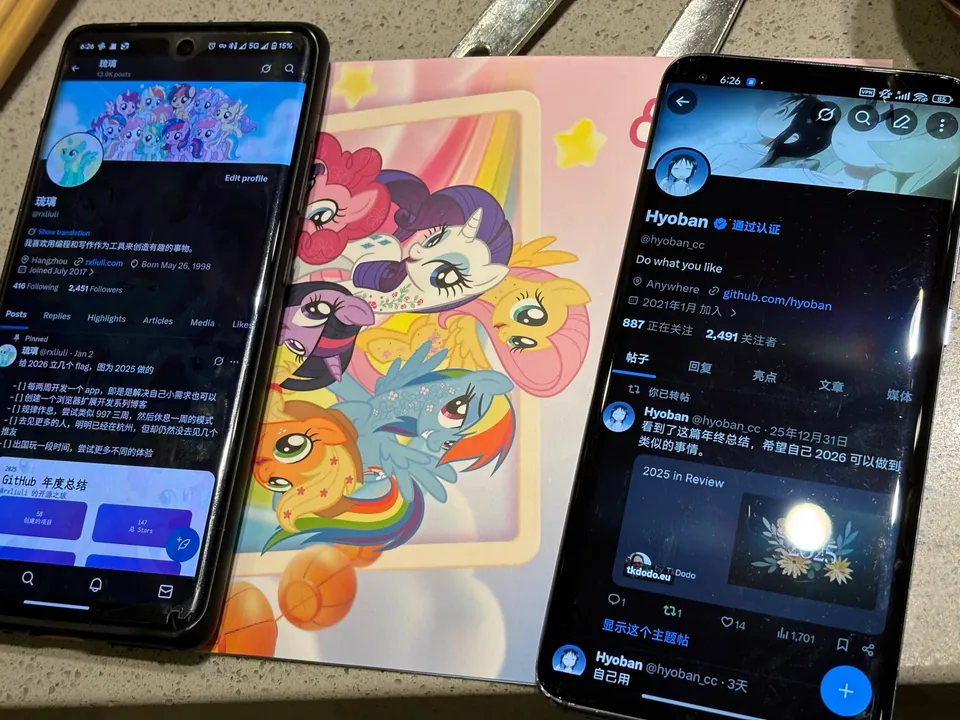 Two phones showing social profiles beside a My Little Pony card on a restaurant table.