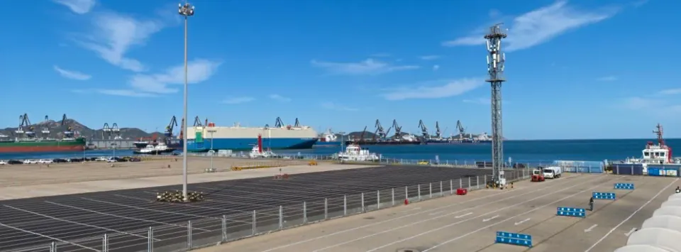 Ferries and loading lanes at a harbor under a bright blue sky.