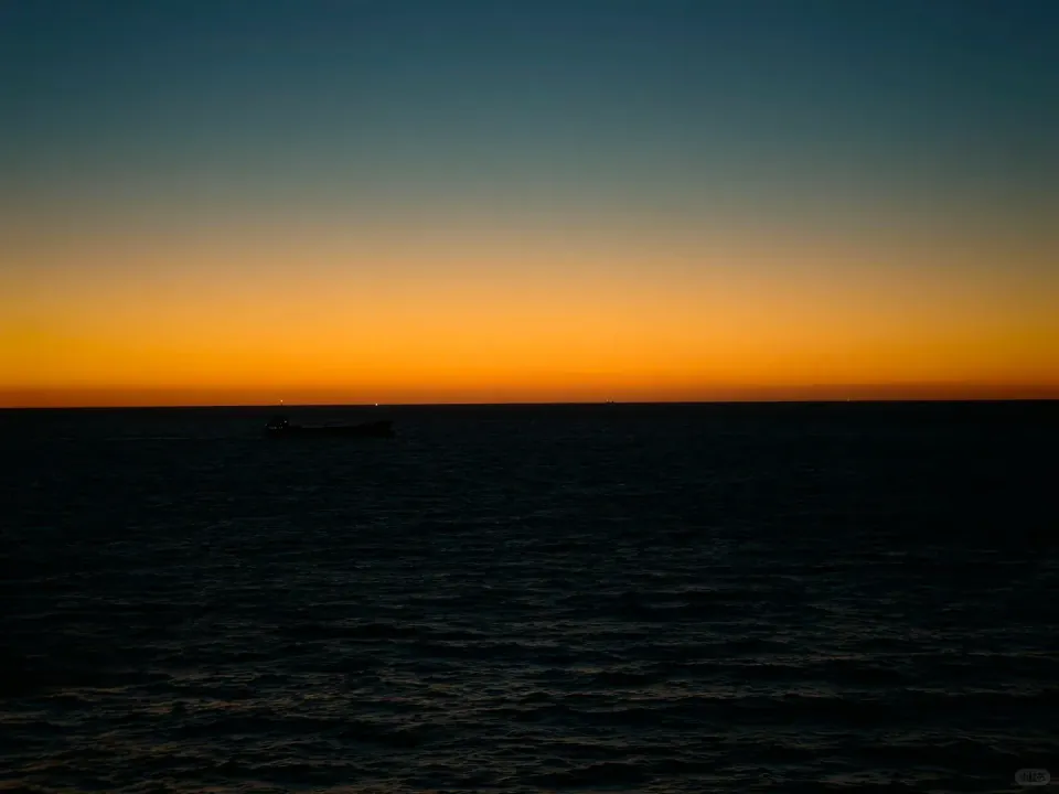 A narrow band of golden twilight over the dark sea.