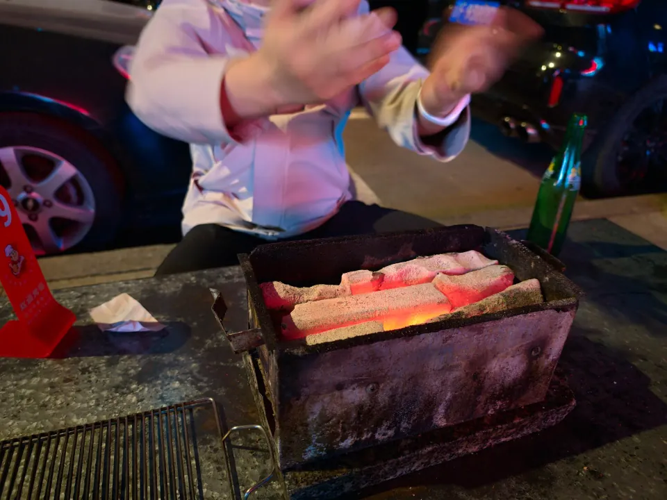 Glowing charcoal in a small tabletop barbecue grill.
