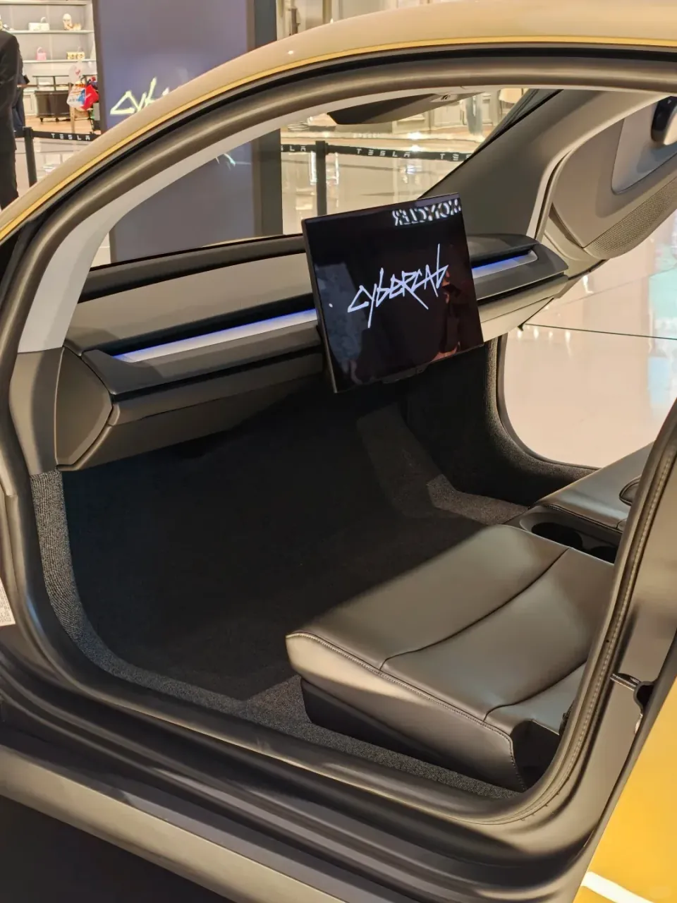 The Tesla Cybercab's seats and central screen, viewed through the open door.
