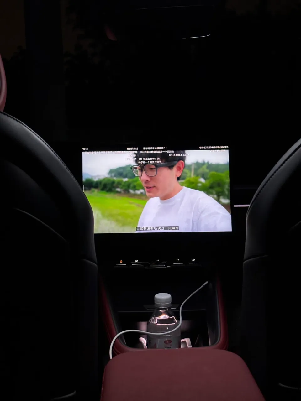 A video playing on the central display between the front seats at night.