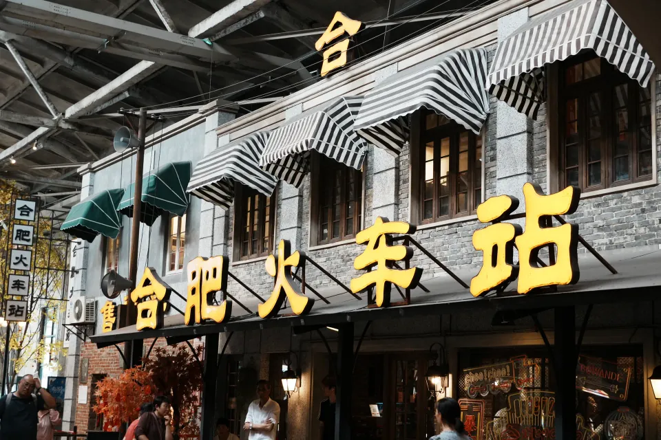 A reconstructed vintage Hefei railway station facade with striped awnings.