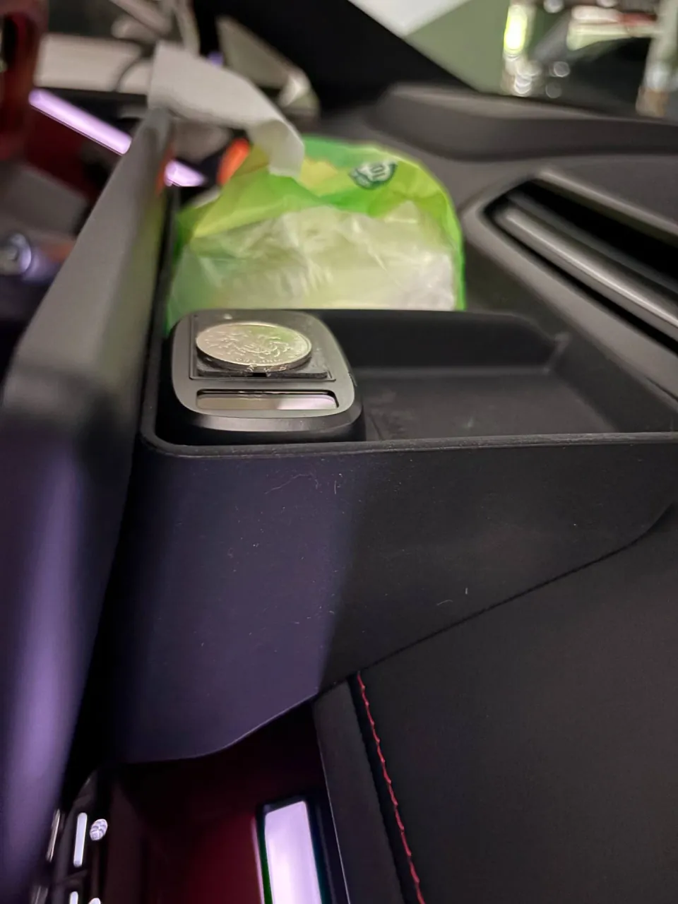 An ETC device fitting snugly in the right compartment of a black car storage box.