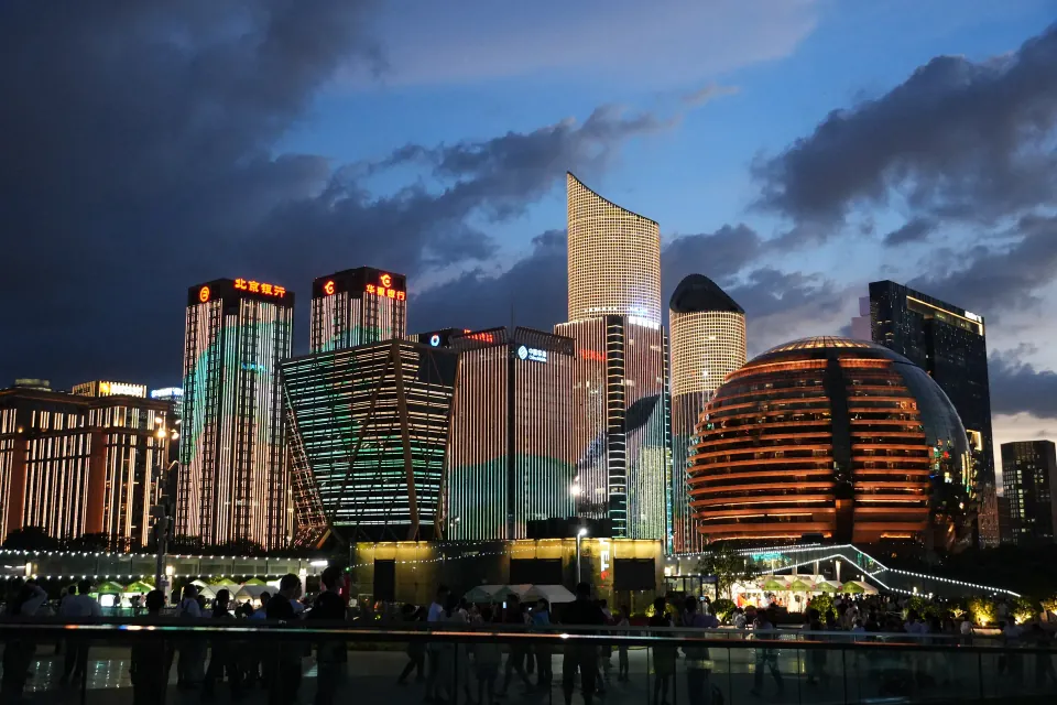 Crowds watching illuminated towers in Qianjiang New City