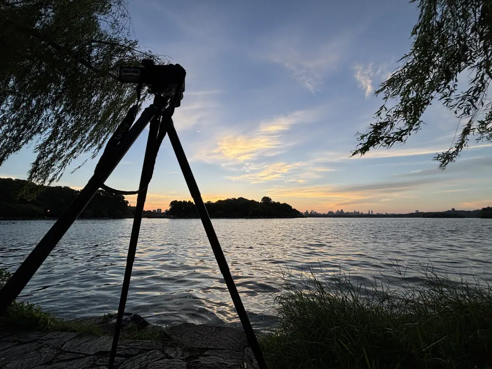 Camera on a tripod facing the sunrise over West Lake