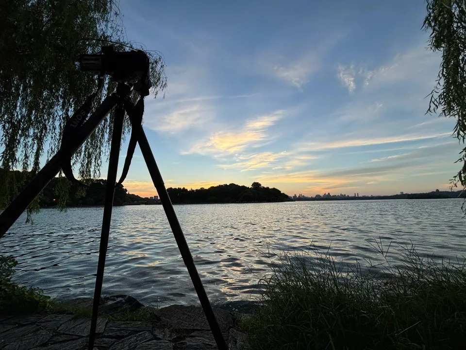Camera on a tripod beside West Lake at dawn