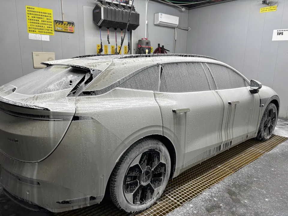 White Zeekr 007 GT covered in foam at a self-service car wash