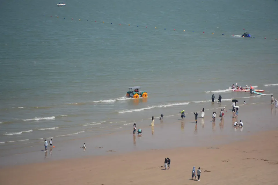 Visitors playing in the shallow water at Liandao beach