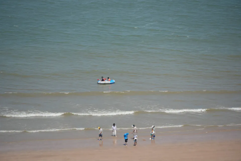 Small boats moving through the shallows off Liandao beach