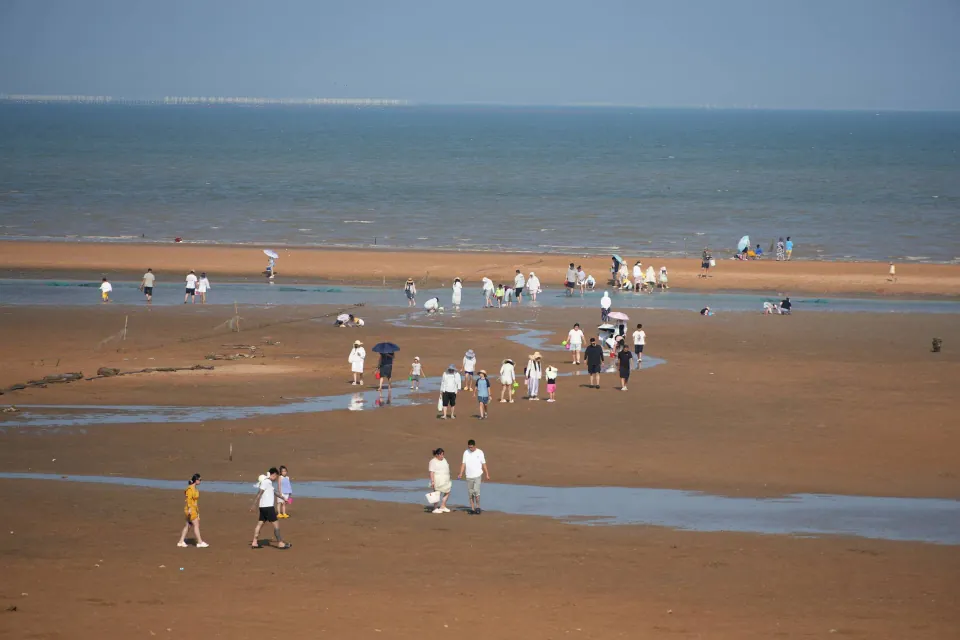 Visitors walking across tidal flats on Liandao