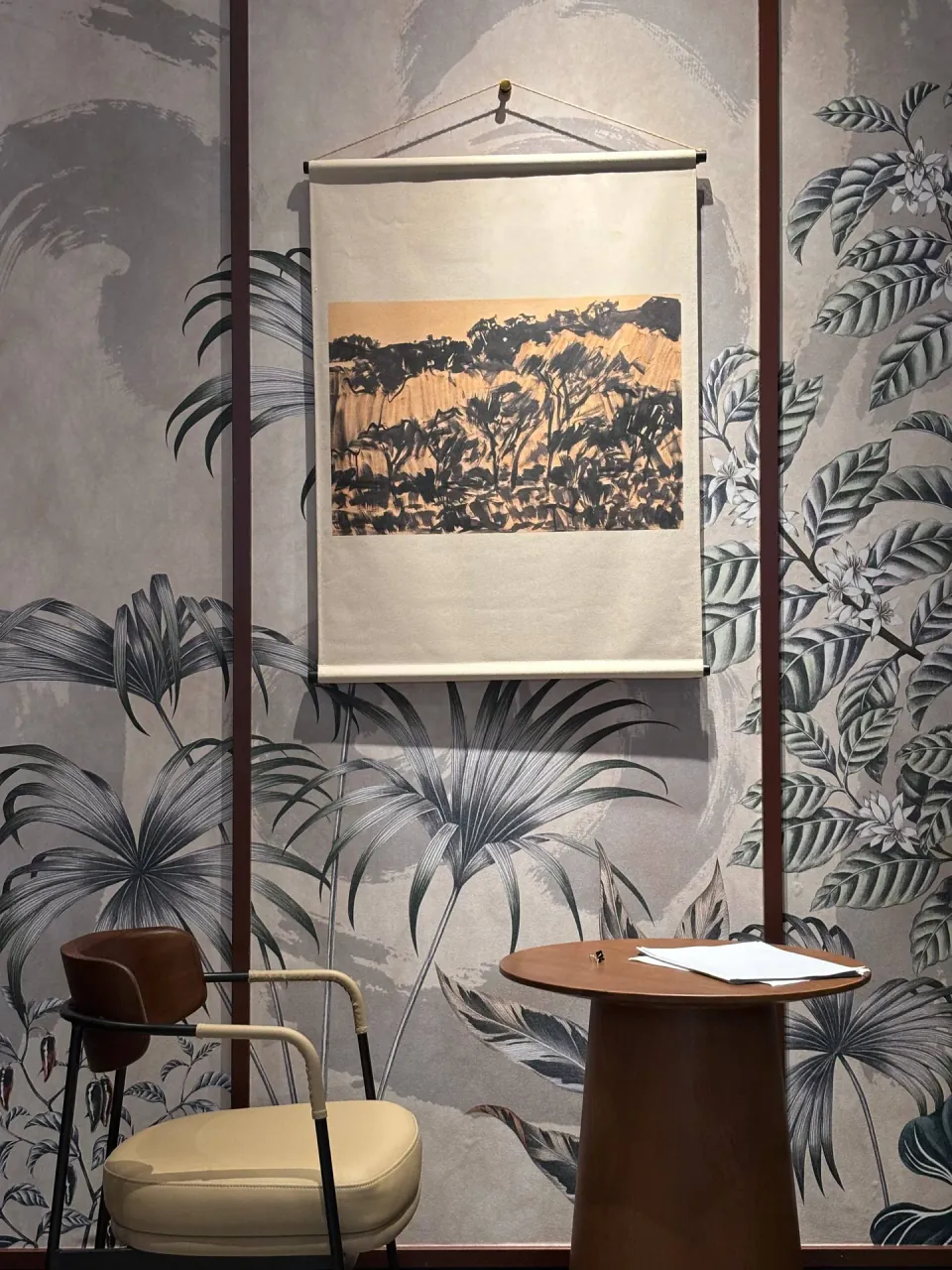 Armchair and side table against botanical wallpaper