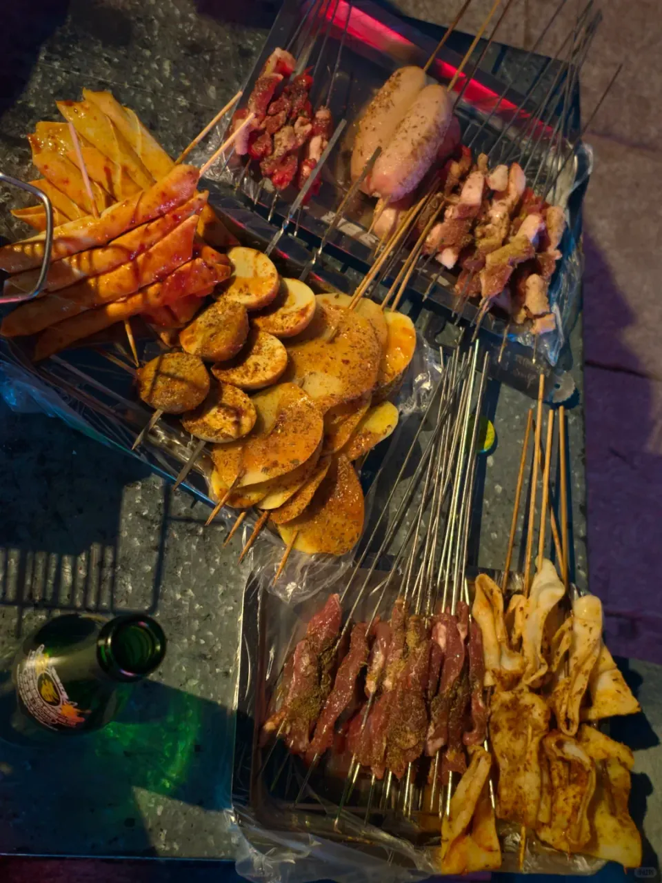 An assortment of grilled skewers arranged beside the barbecue.