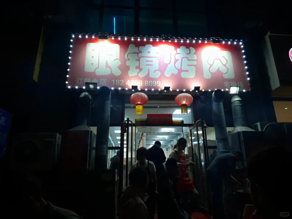The illuminated entrance to a barbecue restaurant at night.
