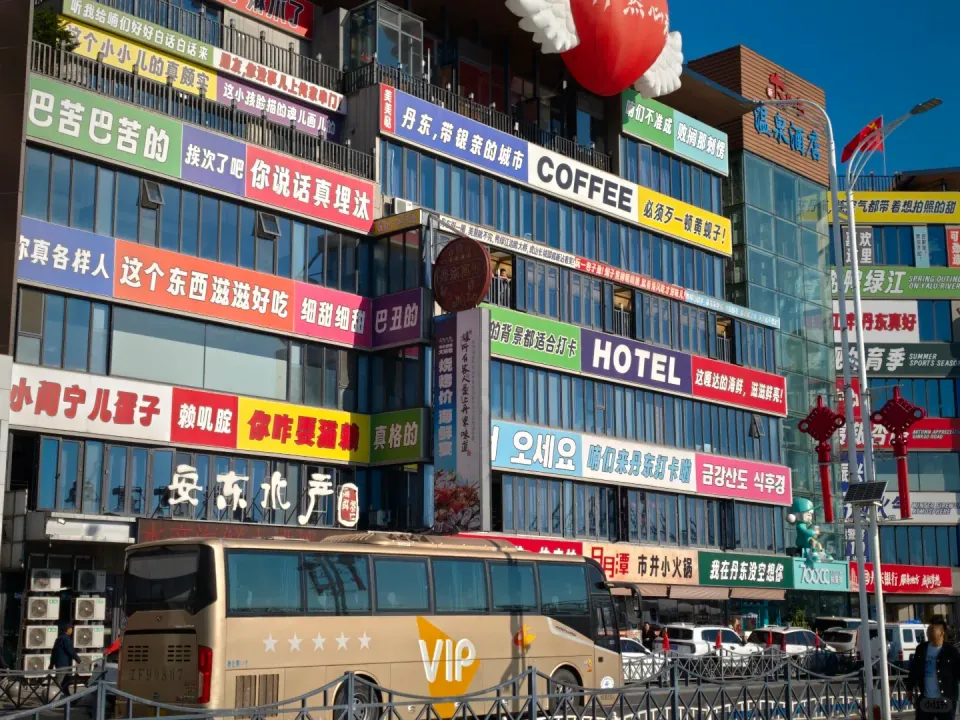 A commercial building covered with colorful restaurant and hotel signs.