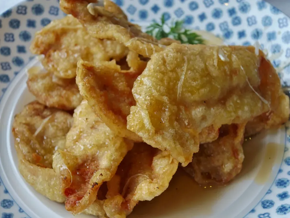 Golden battered pieces of fried food on a patterned plate.