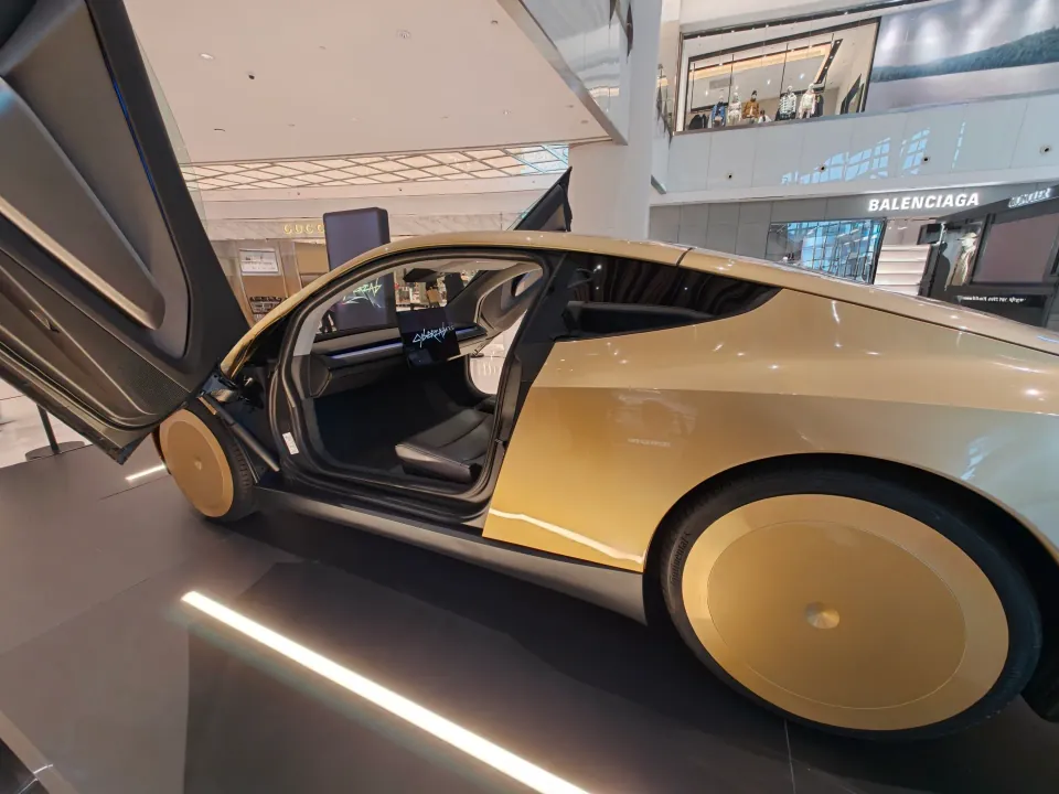 Side view of the Tesla Cybercab with its passenger door open.