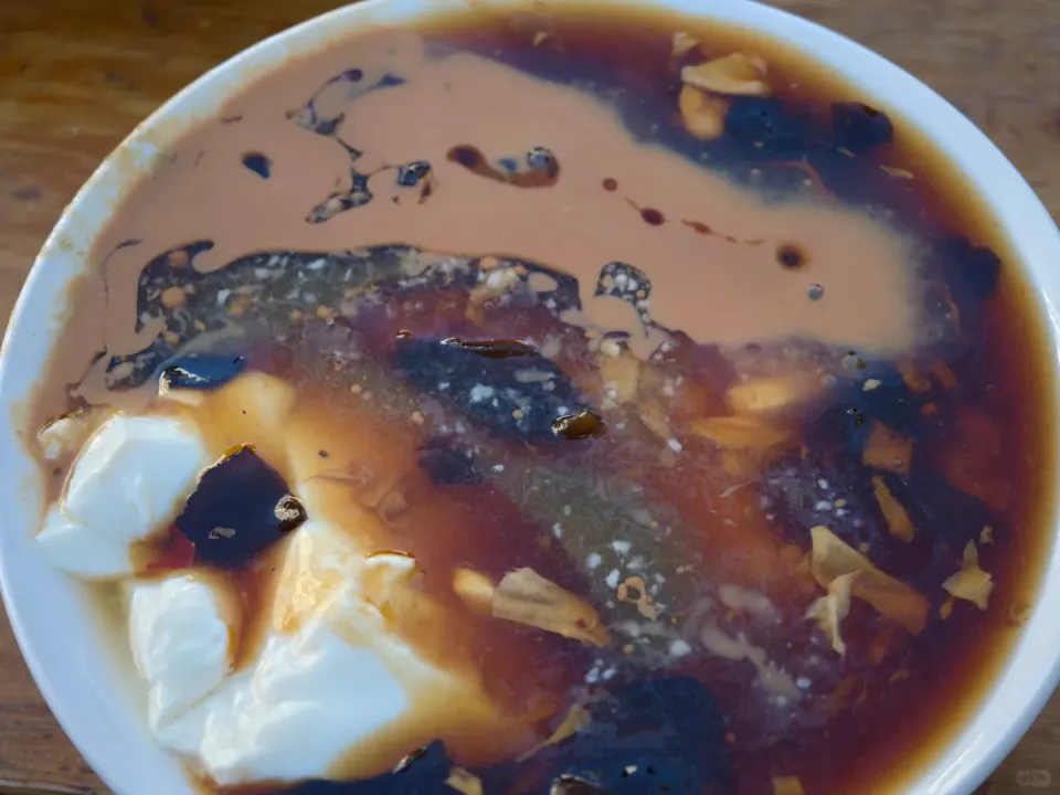 A bowl of soft tofu topped with savory brown gravy.